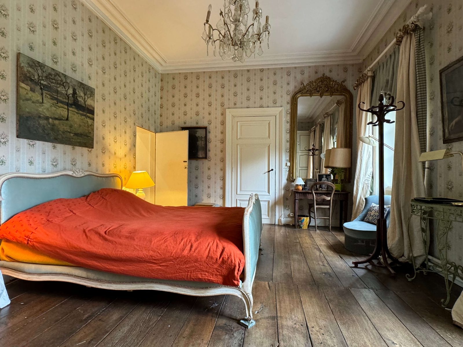 Chambre au lit bleu et couvre-lit rouge